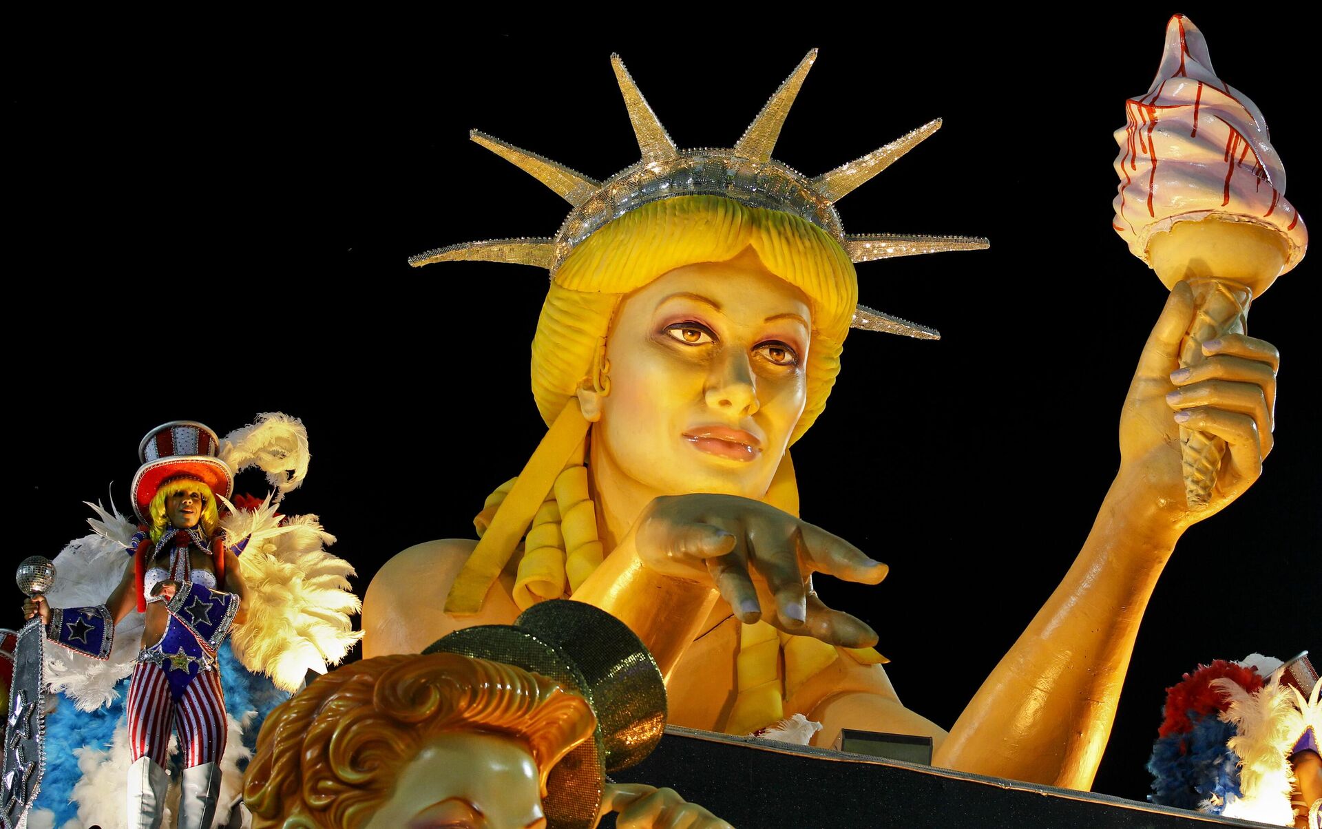 Uma dançarina, à direita, se apresenta em um carro alegórico com uma estátua que lembra a Estátua da Liberdade durante o desfile da escola de samba São Clemente no Sambódromo do Rio de Janeiro, Brasil, 20 de fevereiro de 2012 - Sputnik Brasil, 1920, 28.04.2023