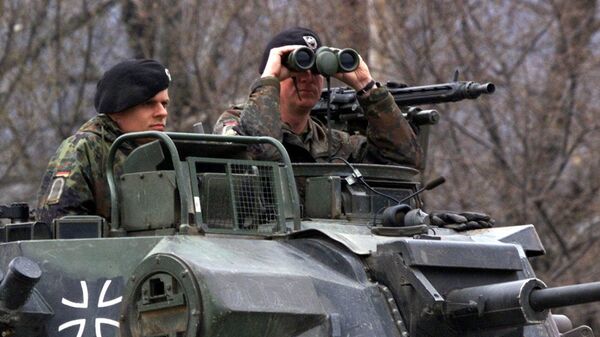 Um oficial alemão do contingente da OTAN implantado na Macedônia olha através de seus binóculos, enquanto sua unidade blindada está posicionada perto de Tetovo, perto da fronteira da província iugoslava de Kosovo, 50 quilômetros a noroeste de Skopje, 29 de março de 1999 - Sputnik Brasil