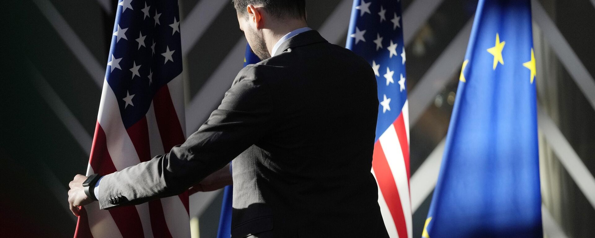 Um trabalhador ajusta as bandeiras dos EUA e da UE antes da chegada do chefe de política externa da União Europeia, Josep Borrell, e do secretário de Estado dos Estados Unidos, Antony Blinken, durante a reunião ministerial do Conselho de Energia UE-EUA no prédio do Conselho Europeu em Bruxelas, 4 de abril de 2023 - Sputnik Brasil, 1920, 13.05.2023