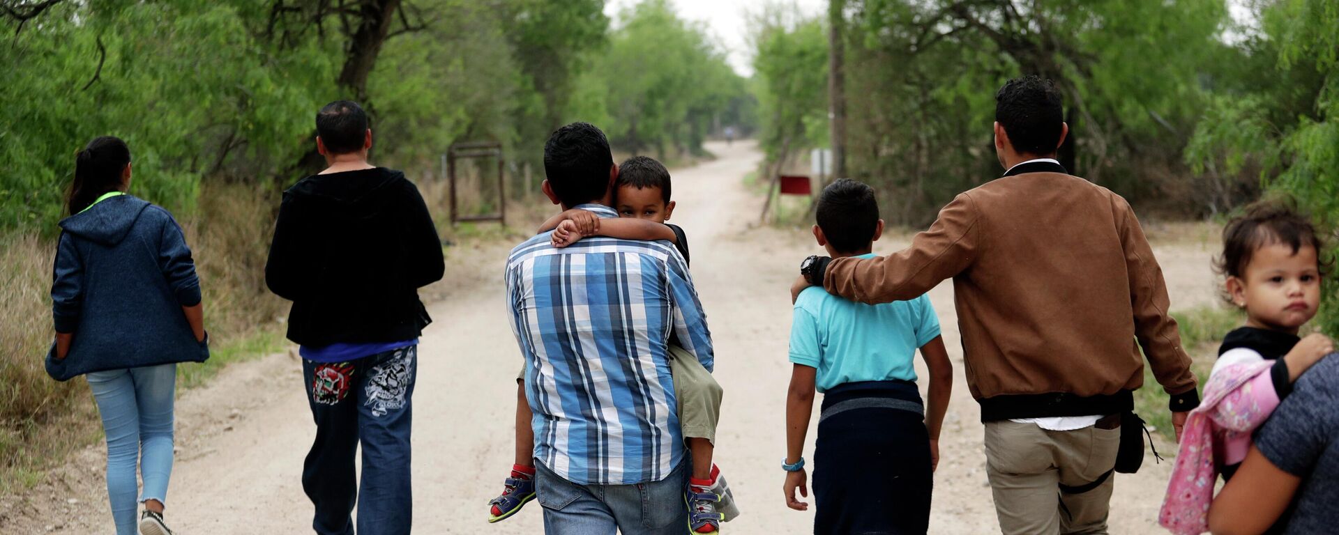 Um grupo de famílias migrantes caminha do Rio Grande, o rio que separa os EUA e o México no Texas, perto de McAllen, Texas, 14 de março de 2019 - Sputnik Brasil, 1920, 02.11.2023