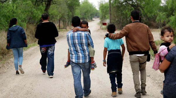 Um grupo de famílias migrantes caminha do Rio Grande, o rio que separa os EUA e o México no Texas, perto de McAllen, Texas, 14 de março de 2019 - Sputnik Brasil