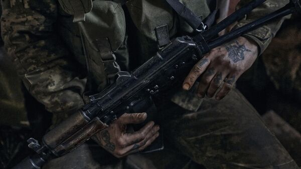 Soldado ucraniano segura uma arma enquanto descansa um pouco na linha de frente no vilarejo de Nova York, região de Donetsk, 24 de abril de 2023. - Sputnik Brasil
