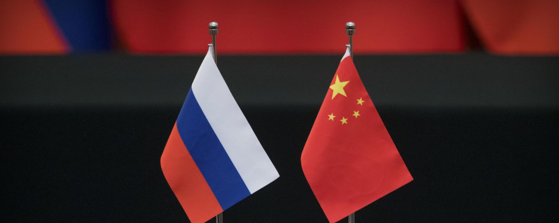 Bandeiras russa e chinesa sobre uma mesa antes de uma cerimônia de assinatura no Grande Salão do Povo, em Pequim. China, 8 de junho de 2018 - Sputnik Brasil, 1920, 07.10.2023