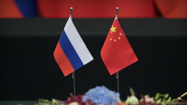 Bandeiras russa e chinesa sobre uma mesa antes de uma cerimônia de assinatura no Grande Salão do Povo, em Pequim. China, 8 de junho de 2018 - Sputnik Brasil