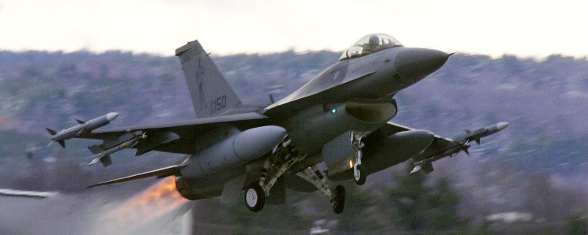Um caça F-16 decola com pós-combustores carregados de mísseis Sidewinder ativos da base da Guarda Aérea Nacional em South Burlington, Vermont, EUA, dezembro de 2001 - Sputnik Brasil, 1920, 18.06.2023