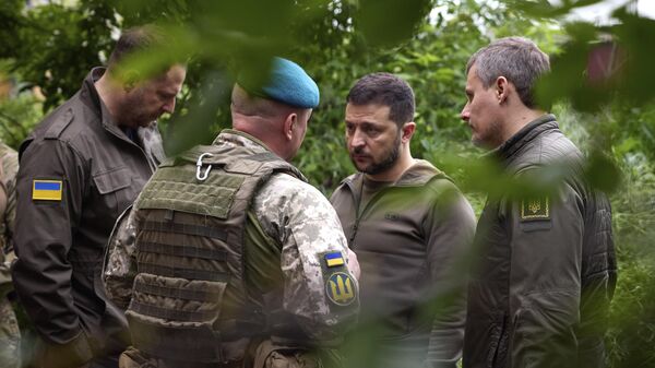 Presidente ucraniano, Vladimir Zelensky, (terceiro da esquerda para a direita), ouve um comandante militar enquanto visita a região de Donetsk, em 23 de maio de 2023 - Sputnik Brasil