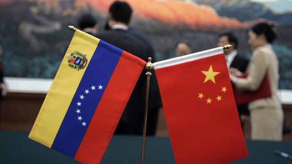 As bandeiras chinesa e venezuelana são colocadas sobre a mesa onde ocorreu a cerimônia de assinatura de acordos entre as duas nações no Grande Salão do Povo em Pequim - Sputnik Brasil