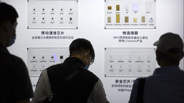 As pessoas olham para os semicondutores em exibição do Tsinghua Unigroup na China Beijing International High Tech Expo em Pequim, sábado, 19 de setembro de 2020 - Sputnik Brasil