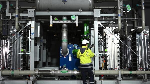 Funcionário da empresa de gases, tecnologias e serviços Air Liquide em frente a um eletrolisador de produção de 2.900 toneladas de hidrogênio por ano, em Oberhausen, Alemanha, 2 de maio de 2023 - Sputnik Brasil