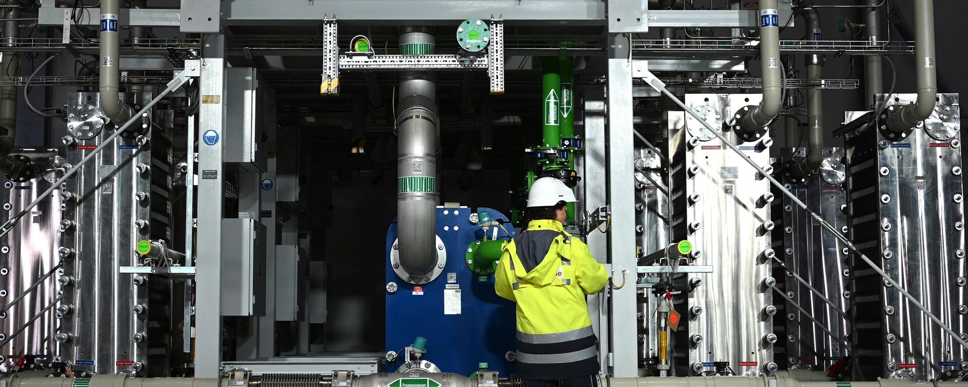 Funcionário da empresa de gases, tecnologias e serviços Air Liquide em frente a um eletrolisador de produção de 2.900 toneladas de hidrogênio por ano, em Oberhausen, Alemanha, 2 de maio de 2023 - Sputnik Brasil, 1920, 26.05.2023