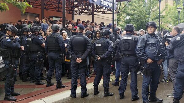 A polícia kosovar de guarda em confronto com sérvios étnicos do lado de fora do prédio da prefeitura em Zvecan, norte de Kosovo, 26 de maio de 2023 - Sputnik Brasil