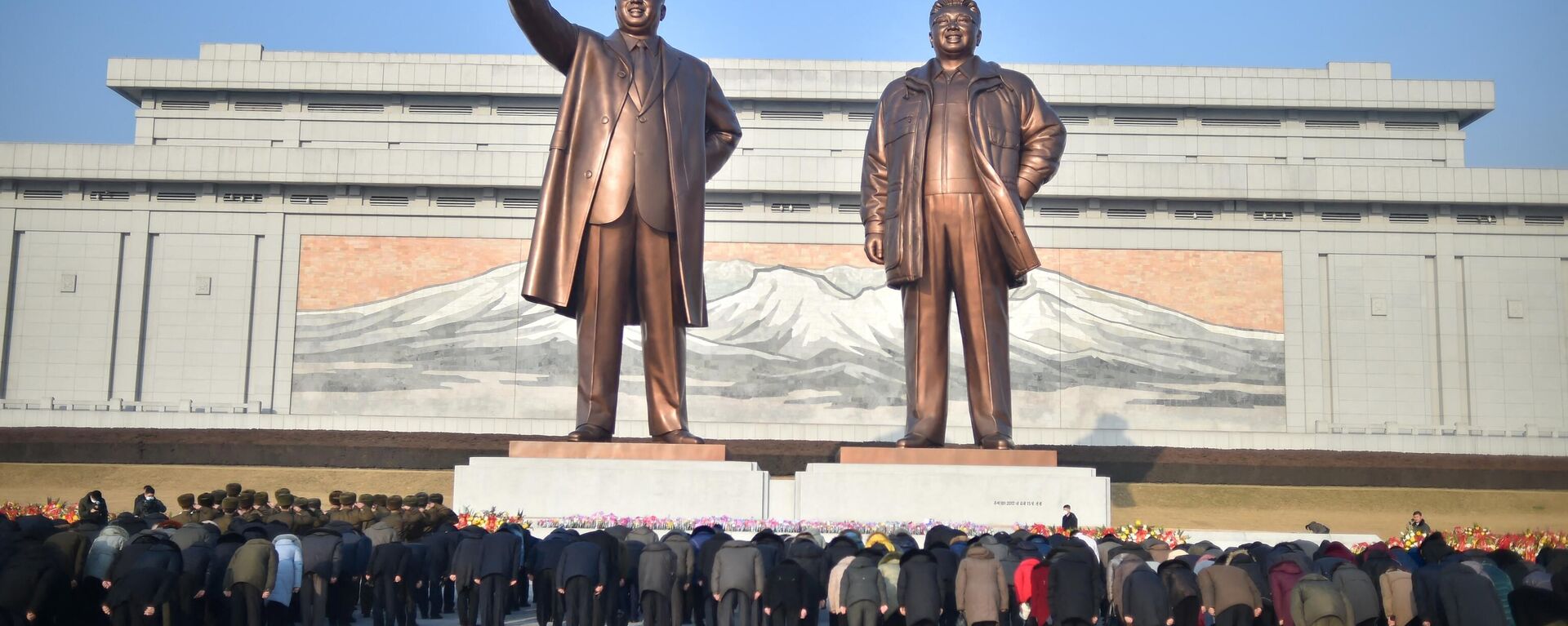 Pessoas observam estátuas dos falecidos líderes norte-coreanos Kim Il-Sung (1948-1994) e Kim Jong-Il (1994-2011) para prestar homenagem por ocasião do aniversário do falecido último líder, em Pyongyang, Coreia do Norte, 16 de fevereiro de 2023 - Sputnik Brasil, 1920, 29.05.2023