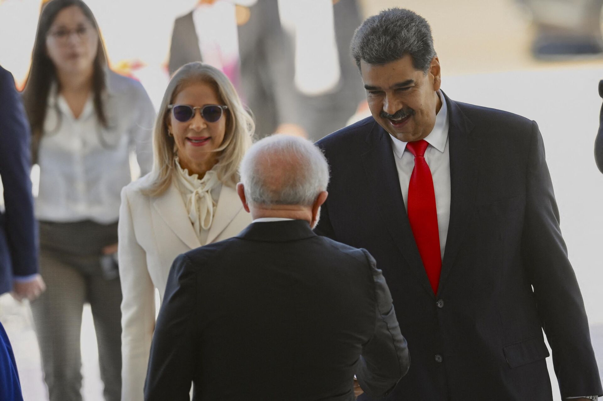O presidente brasileiro Luiz Inácio Lula da Silva (C) cumprimenta o presidente da Venezuela Nicolás Maduro (R) e a primeira-dama Cilia Flores durante uma cerimônia de boas-vindas no Palácio do Planalto em Brasília em 29 de maio de 2023 - Sputnik Brasil, 1920, 31.05.2023