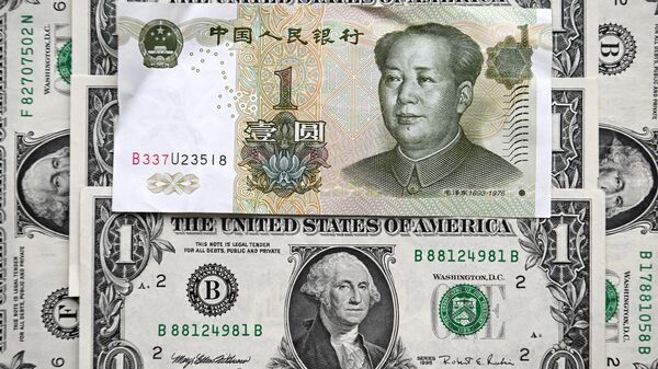 Esta fotografia tirada em 9 de fevereiro de 2023 mostra uma nota de yuan chinês e notas de dólar americano em Moscou. - Sputnik Brasil