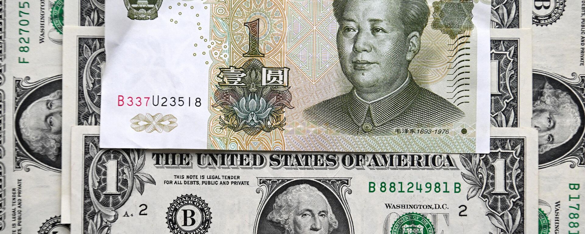 Esta fotografia tirada em 9 de fevereiro de 2023 mostra uma nota de yuan chinês e notas de dólar americano em Moscou. - Sputnik Brasil, 1920, 31.05.2023