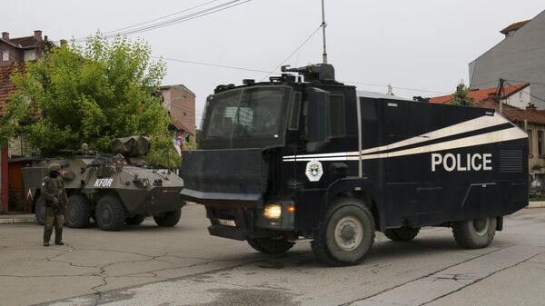 Caminhão de canhão de água da polícia de Kosovo passa enquanto soldados austríacos que servem na missão da OTAN em Kosovo, Força do Kosovo (KFOR, na sigla em inglês), vigiam uma rua na cidade de Zvecan, norte de Kosovo, 1º de junho de 2023 - Sputnik Brasil