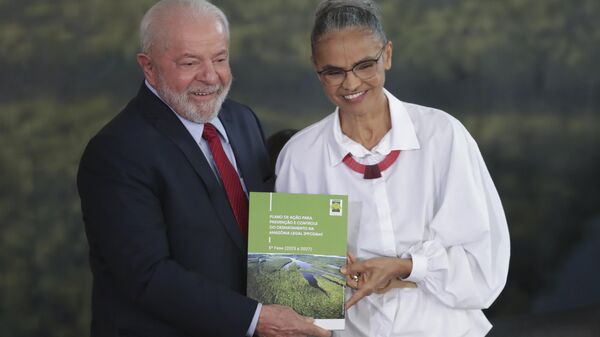 O presidente brasileiro Luiz Inácio Lula da Silva, à esquerda, e sua ministra do Meio Ambiente, Marina Silva, posam com um livro sobre prevenção e controle do desmatamento na região amazônica no Dia Mundial do Meio Ambiente em Brasília, Brasil, 5 de junho de 2023 - Sputnik Brasil