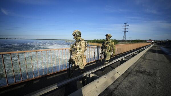 Tropas russas patrulham uma área na usina hidrelétrica de Kakhovka, uma usina a fio d'água no rio Dnieper, na região de Kherson, sul da Ucrânia - Sputnik Brasil