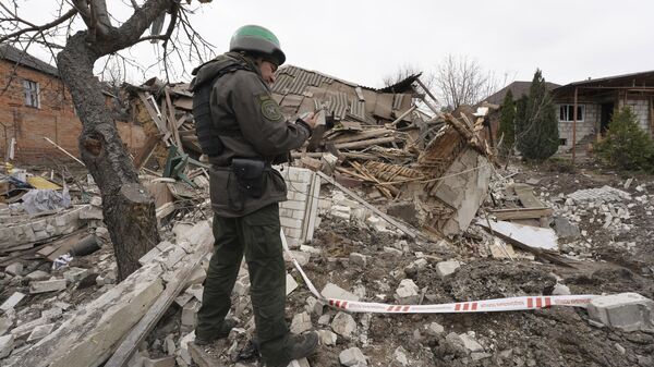 Militar ucraniano junto de casa destruída em Carcóvia, 31 de março de 2023 - Sputnik Brasil
