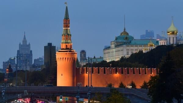 Veículos passam pelas muralhas e torres do Kremlin, com a sede do Ministério das Relações Exteriores da Rússia vista ao fundo, em Moscou - Sputnik Brasil