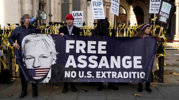 Apoiadores do fundador do WikiLeaks, Julian Assange, seguram cartazes do lado de fora da Corte Real de Justiça em Londres, em 10 de dezembro de 2021 - Sputnik Brasil