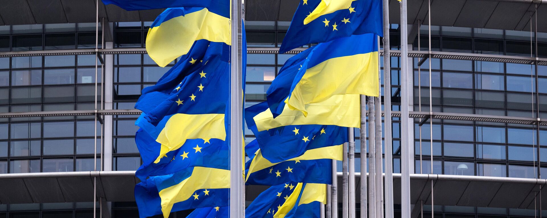 Bandeiras da União Europeia e da Ucrânia tremulando do lado de fora do Parlamento Europeu em Estrasburgo, França, 24 de fevereiro de 2023 - Sputnik Brasil, 1920, 22.07.2023