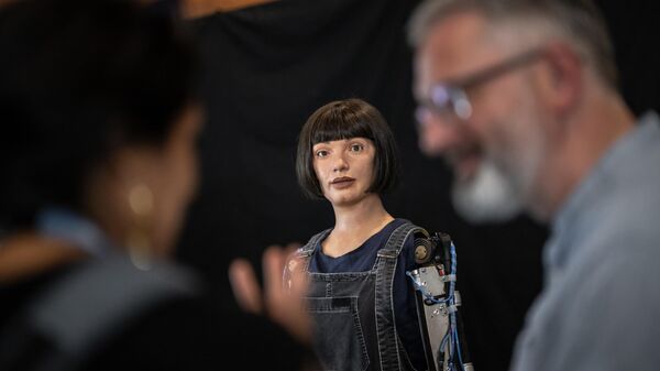 Pessoas falam juntas ao lado do robô artista Ai-Da durante a Cúpula Global da IA para o Bem da União Internacional de Telecomunicações (UIT, na sigla em inglês) em Genebra, Suíça, 5 de julho de 2023 - Sputnik Brasil