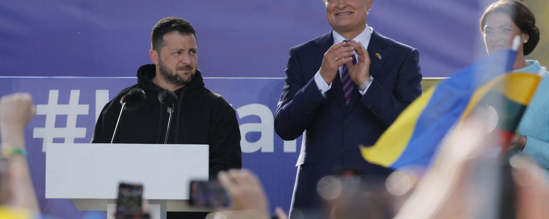 O presidente ucraniano Vladimir Zelensky (E) se dirige à multidão ao lado do presidente da Lituânia, Gitanas Nauseda, e da esposa de Nauseda, Diana Nausediene, na Praça Lukiskiu, em Vilnius, 11 de julho de 2023 - Sputnik Brasil, 1920, 11.07.2023