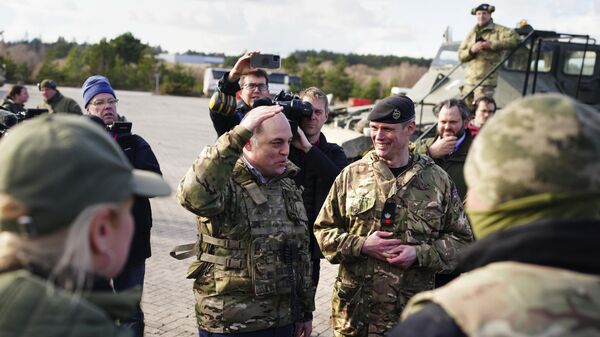 O secretário de Defesa do Reino Unido, Ben Wallace (prestando continência), visita Bovington Camp, uma base militar do Exército britânico onde soldados ucranianos estão treinando em tanques Challenger 2 - Sputnik Brasil