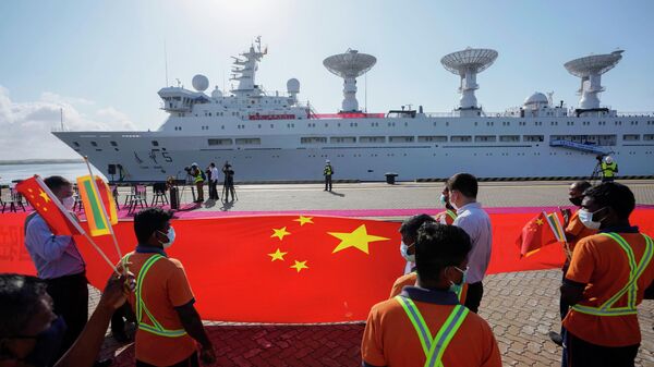 Trabalhadores portuários do Sri Lanka seguram bandeira nacional da China para dar as boas-vindas ao navio de pesquisa chinês Yuan Wang 5, ao chegar ao Porto Internacional de Hambantota, em Hambantota, Sri Lanka, 16 de agosto de 2022 - Sputnik Brasil