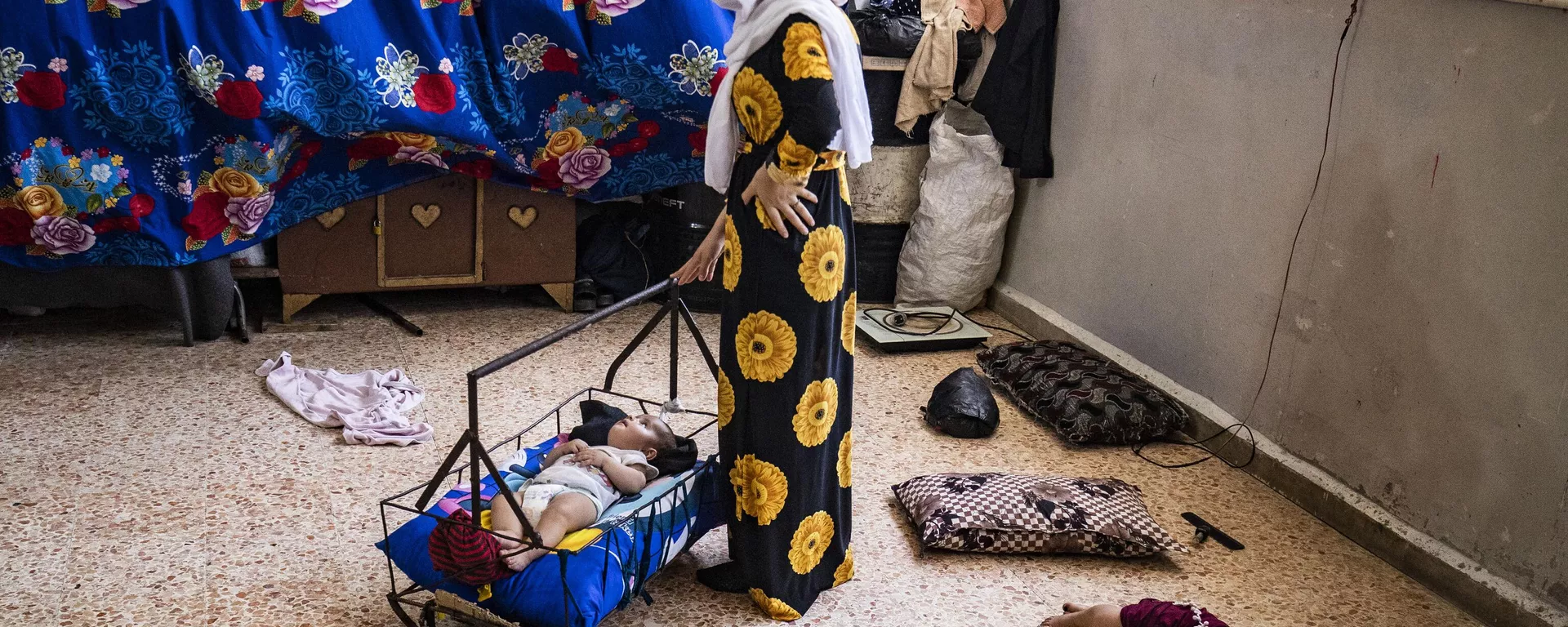 Mãe embala seu bebê para dormir em uma escola que abriga pessoas deslocadas durante onda de calor na província de Al-Hasakah, Síria, em 22 de julho de 2023 - Sputnik Brasil, 1920, 25.07.2023