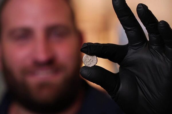 Yaniv David Levy, um estudioso numismático da Autoridade de Antiguidades de Israel, exibe a moeda de 2.000 anos do primeiro ano da revolta judaica - Sputnik Brasil