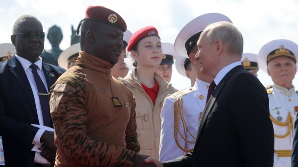 O presidente russo, Vladimir Putin, cumprimenta o presidente interino de Burkina Faso, capitão Ibrahim Traoré, durante um desfile marcando o Dia da Marinha em São Petersburgo, Rússia, 30 de julho de 2023 - Sputnik Brasil