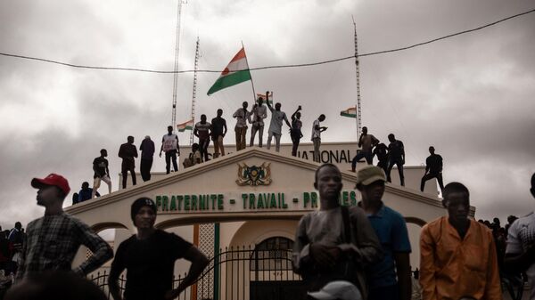 Manifestantes seguram uma bandeira do Níger durante uma manifestação no dia da independência em Niamey em 3 de agosto de 2023 - Sputnik Brasil