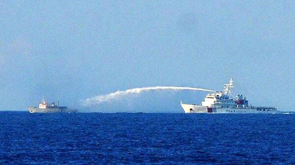 Navio da Guarda Costeira Chinesa (D) usando um canhão de água para atacar um barco vietnamita de Vigilância de Pesca perto do local da plataforma de petróleo chinesa em águas disputadas do mar do Sul da China, na costa central do Vietnã, 2 de junho de 2014 - Sputnik Brasil