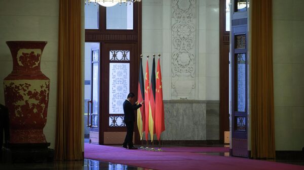 Um trabalhador ajusta as bandeiras da Alemanha e da China no Grande Salão do Povo em Pequim (foto de arquivo) - Sputnik Brasil
