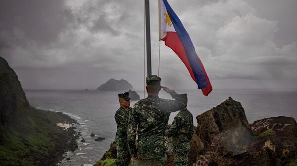 Soldados filipinos participam de cerimônia de hasteamento de bandeira na Ilha Mavulis, Batanes, 29 de junho de 2023 - Sputnik Brasil