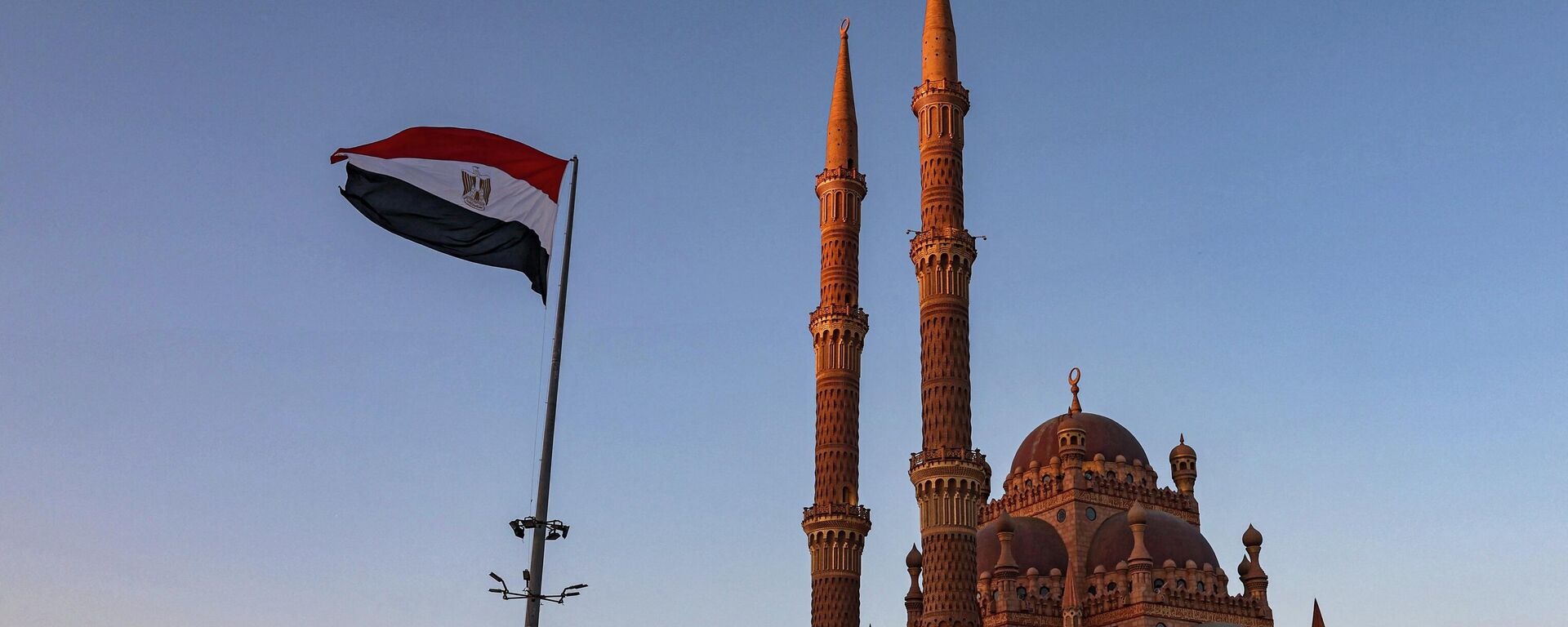 Uma bandeira egípcia tremula do lado de fora da Grande Mesquita de al-Sahaba (Companheiros do Profeta) durante a conferência do clima COP27 na cidade turística de Sharm el-Sheikh, no mar Vermelho, no Egito, em 19 de novembro de 2022 - Sputnik Brasil, 1920, 11.08.2023