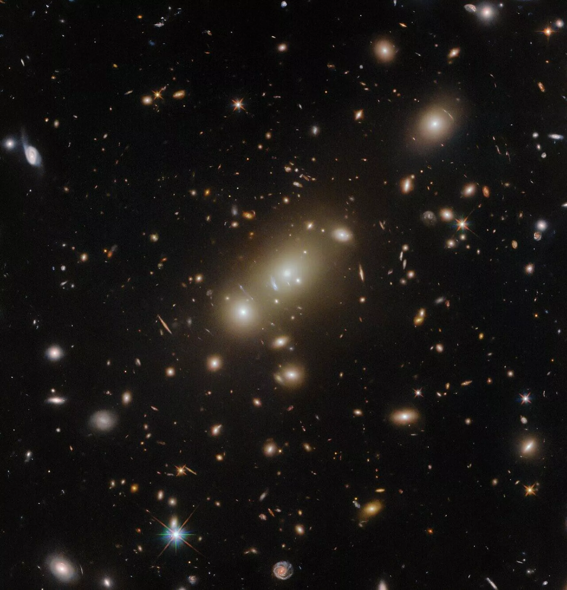 Aglomerado de galáxias verdadeiramente massivo, denominado 2MASX J05101744-4519179, flagrado pelo Telescópio Espacial Hubble a aproximadamente 2,6 bilhões de anos-luz da Terra Aglomerado de galáxias verdadeiramente massivo, denominado 2MASX J05101744-4519179, flagrado pelo Telescópio Espacial Hubble a aproximadamente 2,6 bilhões de anos-luz da Terra
