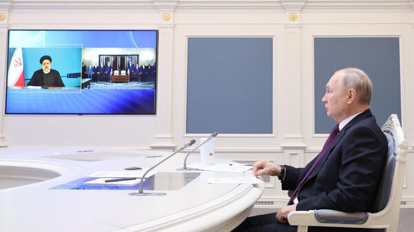 O presidente russo, Vladimir Putin, juntamente com o presidente iraniano, Ebrahim Raisi, participa da cerimônia de assinatura do acordo para a construção da ferrovia Rasht-Astara por videoconferência no Kremlin, em Moscou, na Rússia - Sputnik Brasil