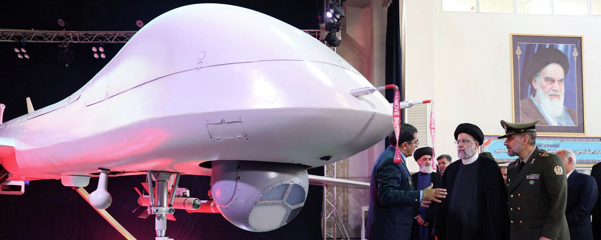 O presidente iraniano Ebrahim Raisi (C) ouve o Chefe das Indústrias de Aviação das Forças Armadas, general Afshin Khajehfard (E), enquanto o Ministro da Defesa, general Mohammad Reza Gharaei Ashtiani (D), escuta atentamente, durante a cerimônia de lançamento do drone Mohajer-10, 22 de agosto de 2023 - Sputnik Brasil, 1920, 23.08.2023