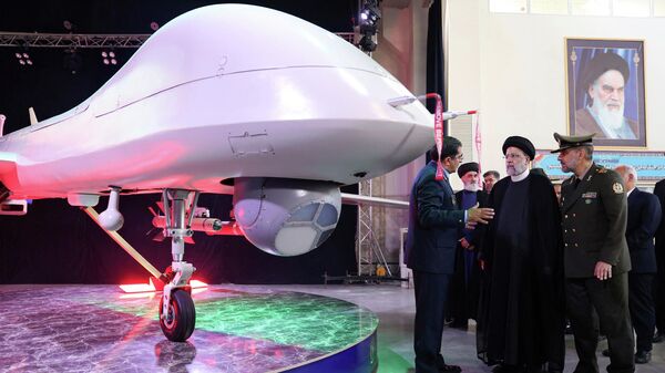 O presidente iraniano Ebrahim Raisi (C) ouve o Chefe das Indústrias de Aviação das Forças Armadas, general Afshin Khajehfard (E), enquanto o Ministro da Defesa, general Mohammad Reza Gharaei Ashtiani (D), escuta atentamente, durante a cerimônia de lançamento do drone Mohajer-10, 22 de agosto de 2023 - Sputnik Brasil