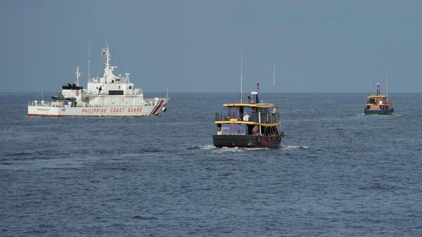 Barcos de abastecimento das Filipinas (à direita) são escoltados pelo BRP Sindangan, da Guarda Costeira filipina (à esquerda) enquanto navios da Guarda Costeira da China (fora da foto) tentam bloqueá-los no Second Thomas Shoal, local disputado no mar do Sul da China, durante missão de rotação e reabastecimento em 22 de agosto de 2023 - Sputnik Brasil