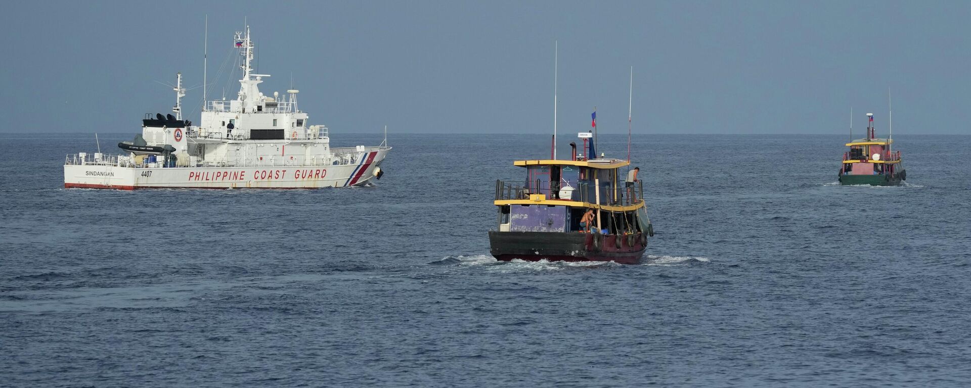 Barcos de abastecimento das Filipinas (à direita) são escoltados pelo BRP Sindangan, da Guarda Costeira filipina (à esquerda) enquanto navios da Guarda Costeira da China (fora da foto) tentam bloqueá-los no Second Thomas Shoal, local disputado no mar do Sul da China, durante missão de rotação e reabastecimento em 22 de agosto de 2023 - Sputnik Brasil, 1920, 24.08.2023