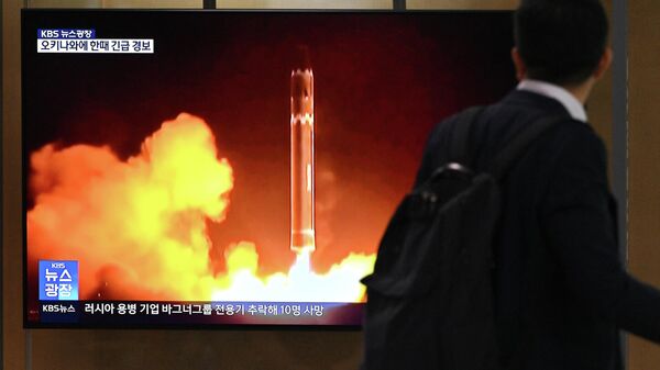 Homem passa por tela televisiva que mostra um noticiário com imagens de um teste de míssil da Coreia do Norte, em uma estação de trem em Seul, Coreia do Sul, 24 de agosto de 2023 - Sputnik Brasil
