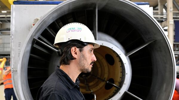 Funcionário da empresa alemã Siemens Energy em frente a uma turbina do gasoduto Nord Stream 1 na fábrica da Siemens Energy em Muelheim an der Ruhr, Alemanha, depois que o motor recebeu trabalho de manutenção no Canadá, 3 de agosto de 2022 - Sputnik Brasil