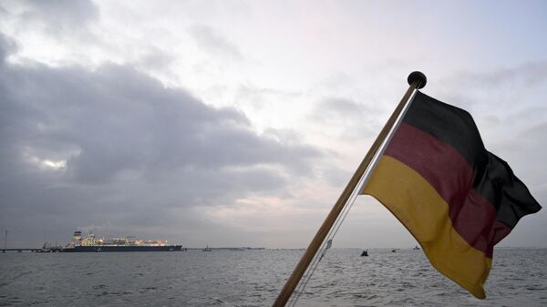 A bandeira nacional alemã tremula enquanto o navio Hoegh Esperanza da Unidade Flutuante de Armazenamento e Regaseificação atraca no terminal de Gás Natural Liquefeito (GNL) no porto de Wilhelmshaven, norte da Alemanha, 15 de dezembro de 2022 - Sputnik Brasil