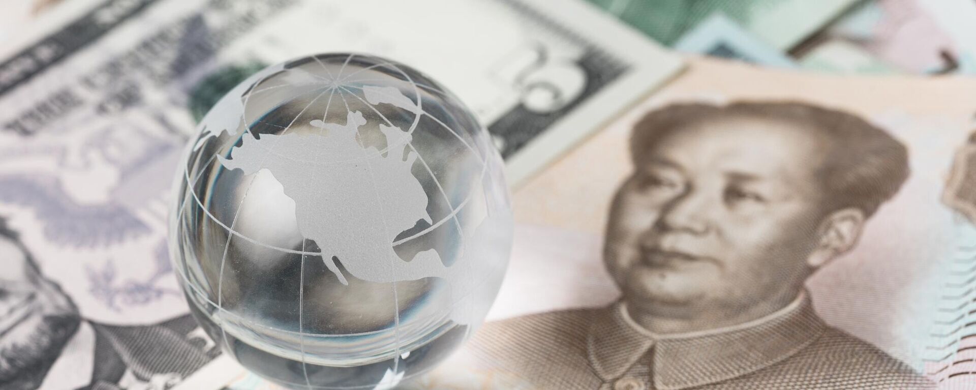 Cédulas de dólar americano e yuan chinês sob um globo de vidro - Sputnik Brasil, 1920, 05.09.2023