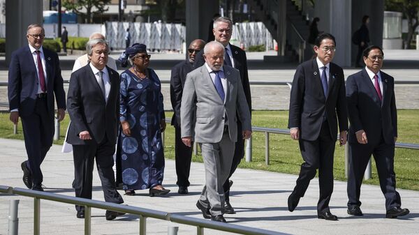 A partir da direita, o primeiro-ministro do Vietnã, Pham Minh Chinh, o primeiro-ministro do Japão, Fumio Kishida, o secretário-geral da OCDE, Mathias Cormann, o presidente do Brasil, Luiz Inácio Lula da Silva, o presidente de Comores, Azali Assoumani, a diretora-geral da OMC, Ngozi Okonjo-Iweala, o secretário-geral das Nações Unidas, Antonio Guterres, o primeiro-ministro da Índia, Narendra Modi, obscuro, e o primeiro-ministro da Austrália, Anthony Albanese, 21 de maio de 2023, à margem da cúpula do G7
 - Sputnik Brasil
