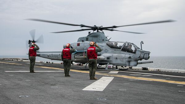 Os companheiros do contramestre da aviação saúdam os pilotos de um helicóptero de ataque AH-1Z Viper enquanto ele se aproxima para pousar a bordo do navio de assalto anfíbio classe Wasp USS Kearsarge (LHD 3) durante o exercício BALTOPS 22 no mar Báltico, 7 de junho de 2022 - Sputnik Brasil